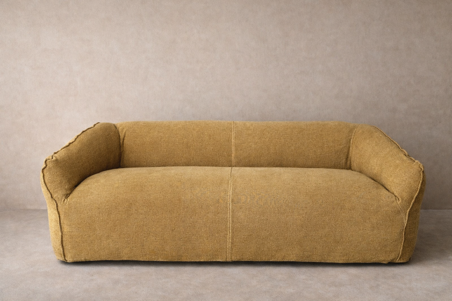 Cousin Sofa in gold ochre linen upholstery, featuring a low continuous form, rounded arms and deep seating