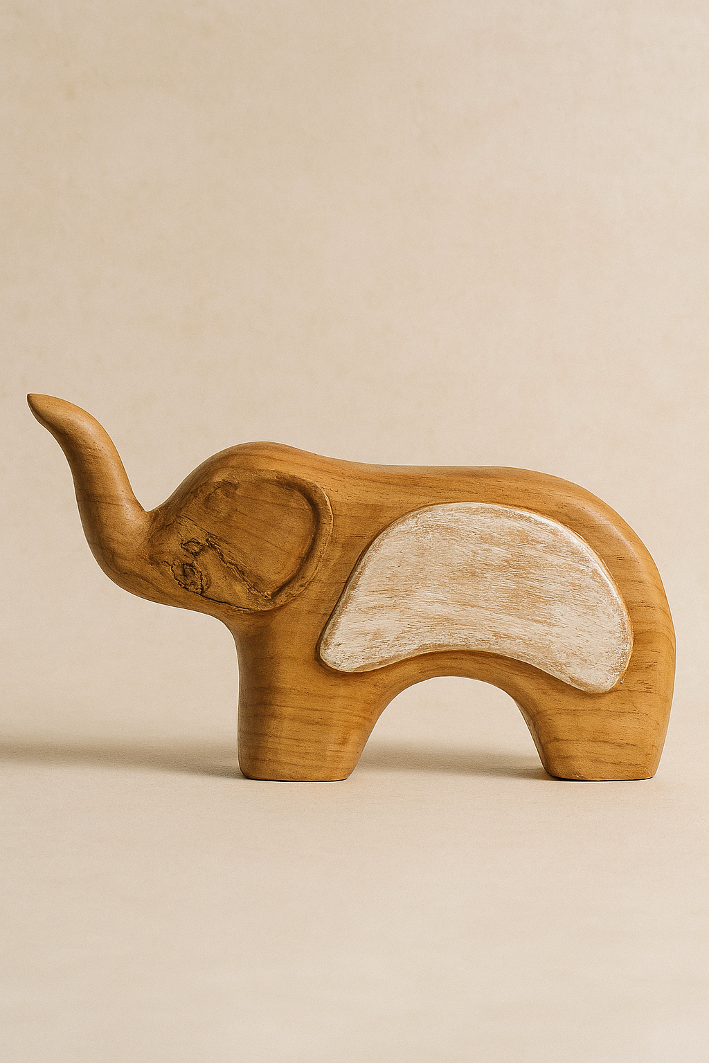 Hand-carved wooden elephant sculpture named Juba with organic texture and natural finish, displayed against a light neutral background.