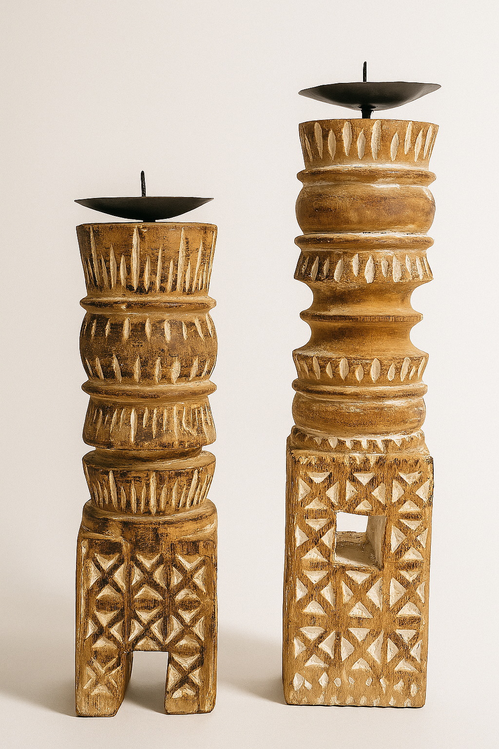 Two wooden candle holders with intricate carvings on a white background