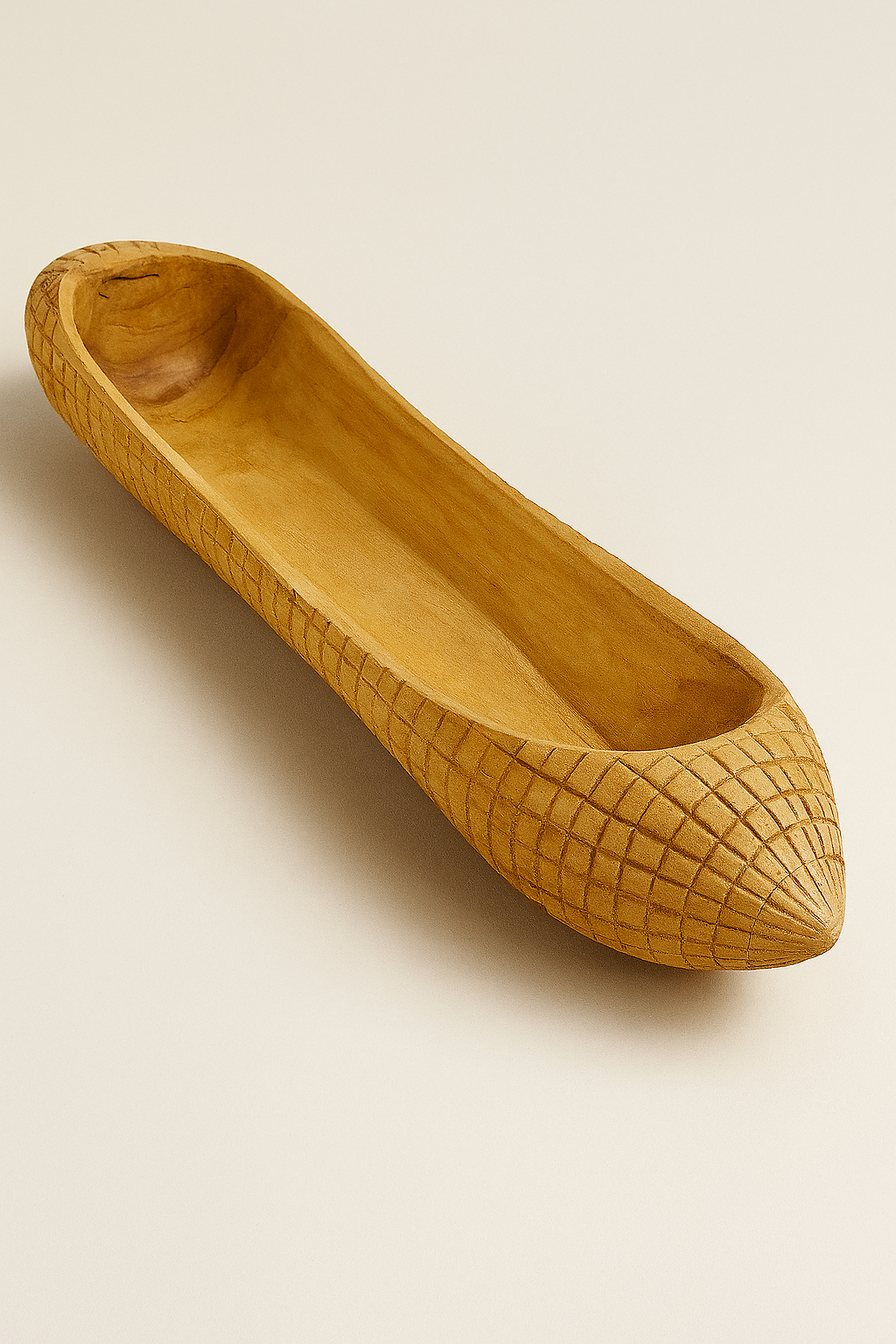 Wooden hand carved canoe with textured surface on a beige background