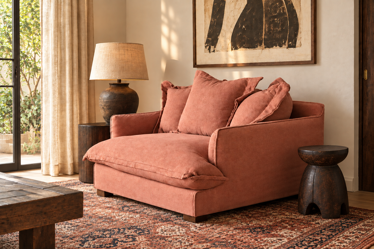 GOA Armchair in terracotta linen upholstery styled in a warm living room setting with a Persian rug and natural light