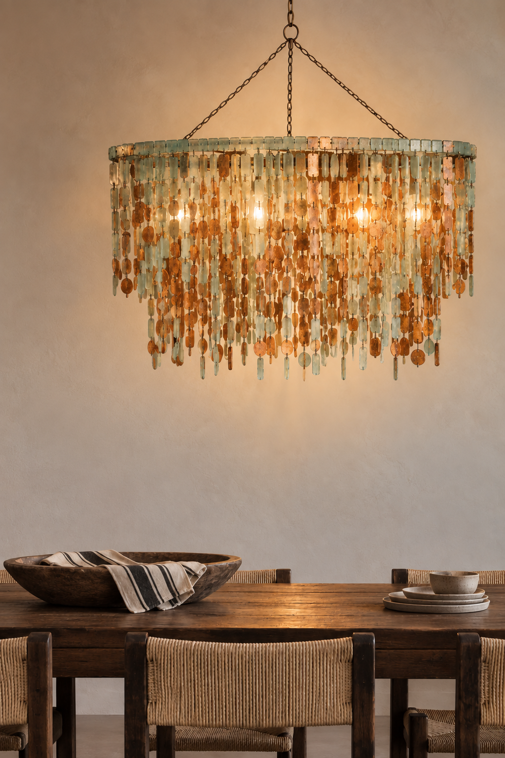 Katundu chandelier with tumbled glass pieces in white, aqua, green and brown, hand-wrapped in copper wire and suspended from a welded frame with copper discs and strips.