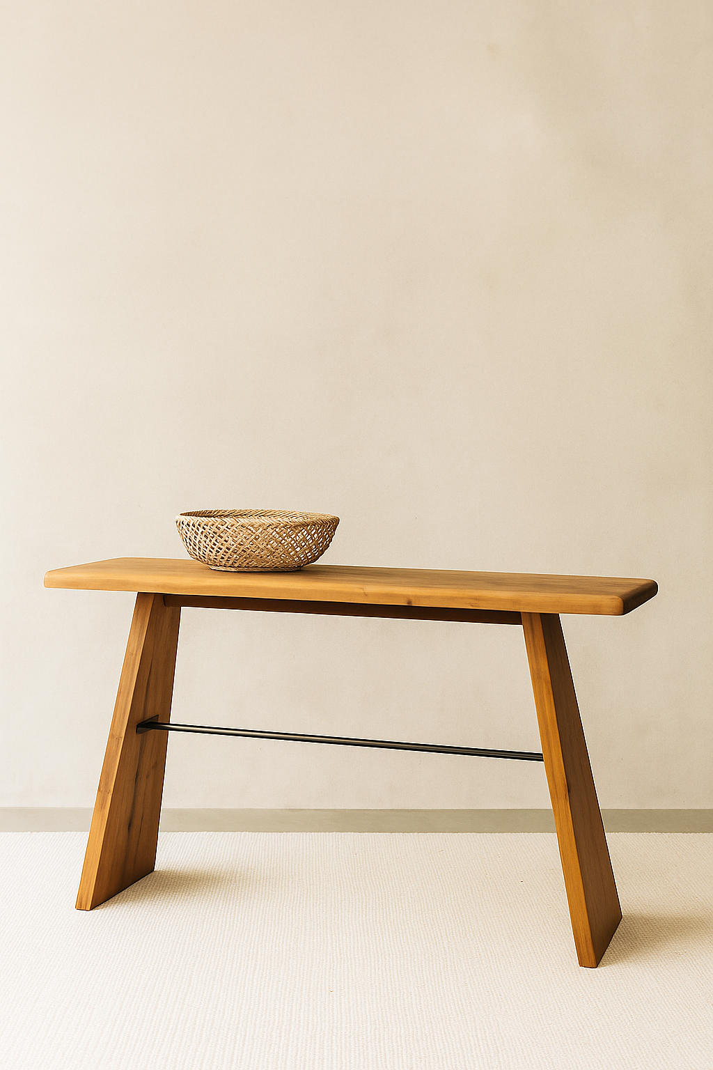 Ndoto console table made of solid wood with angled legs and a woven basket on top, placed against a soft neutral wall on a light textured rug.