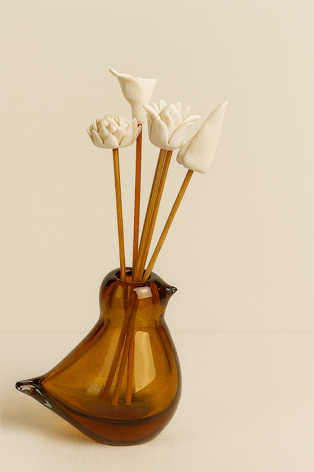 Amber glass diffuser bottle with wooden sticks and white floral tops on a beige background